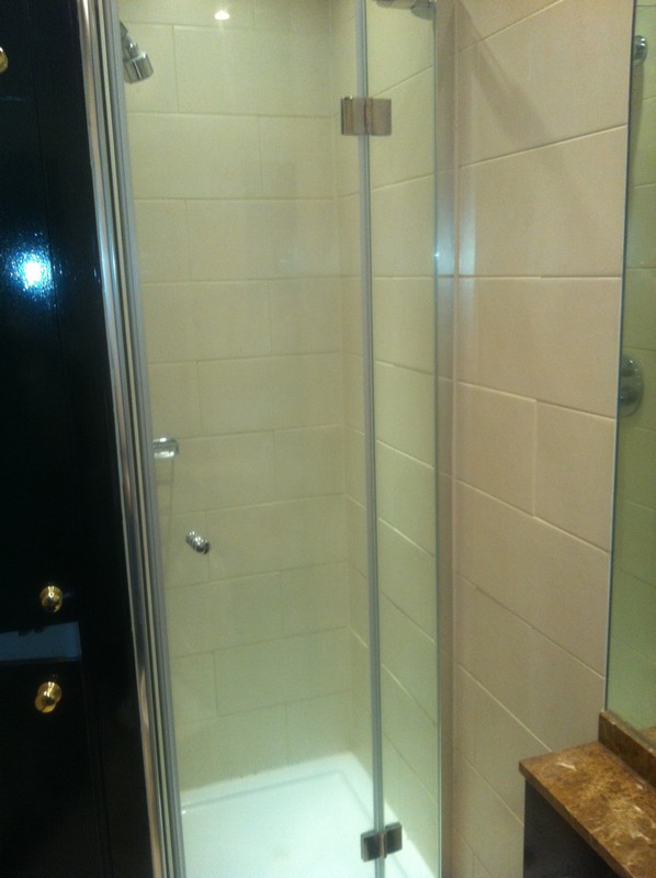 Frameless glass shower enclosure with chrome fittings in Harlesden